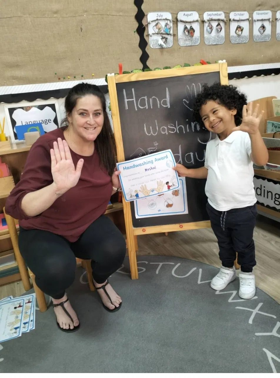 Teacher and child celebrating a handwashing award