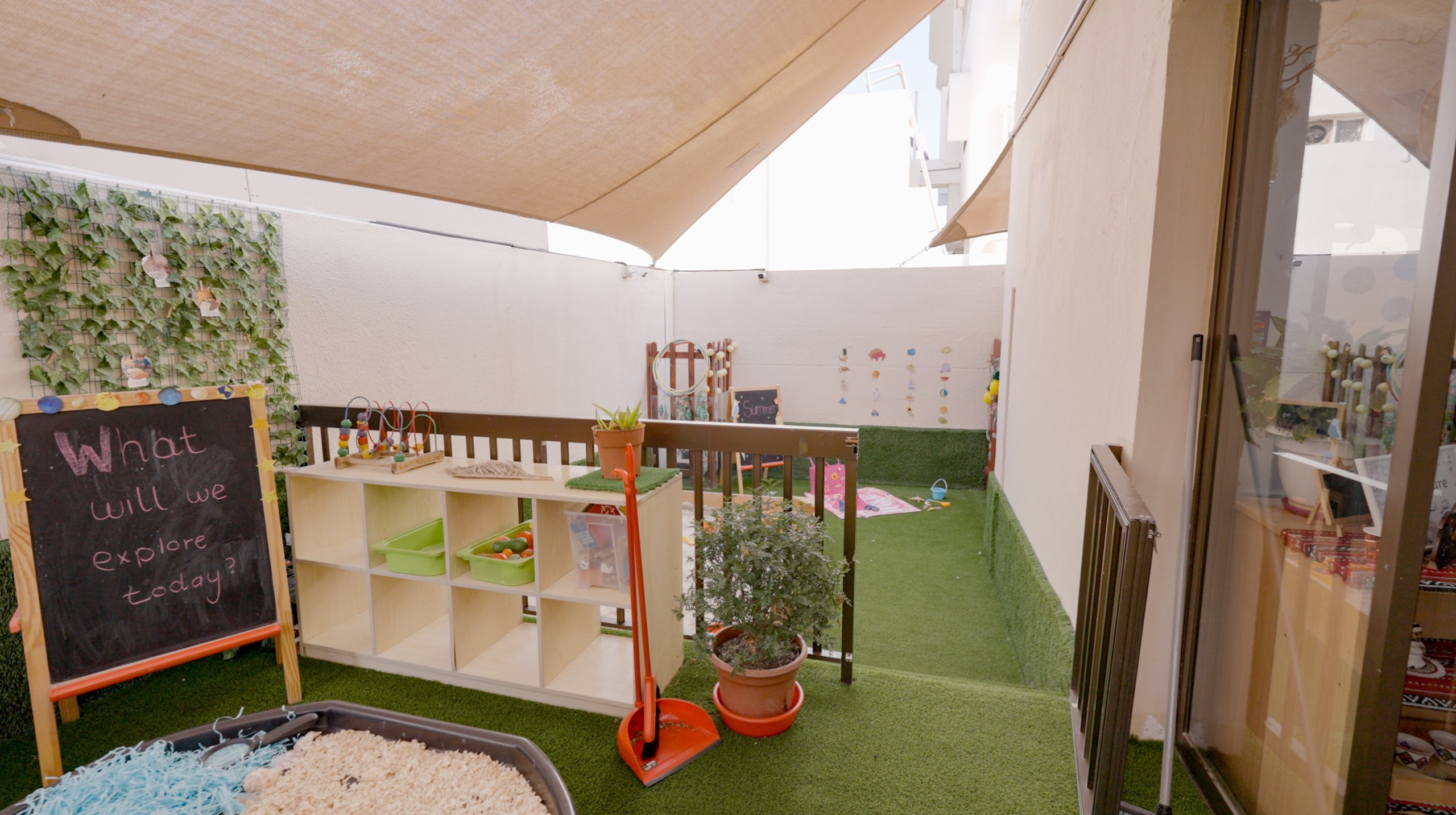 Outdoor terrace exploration area with a "what will we explore today" chalkboard