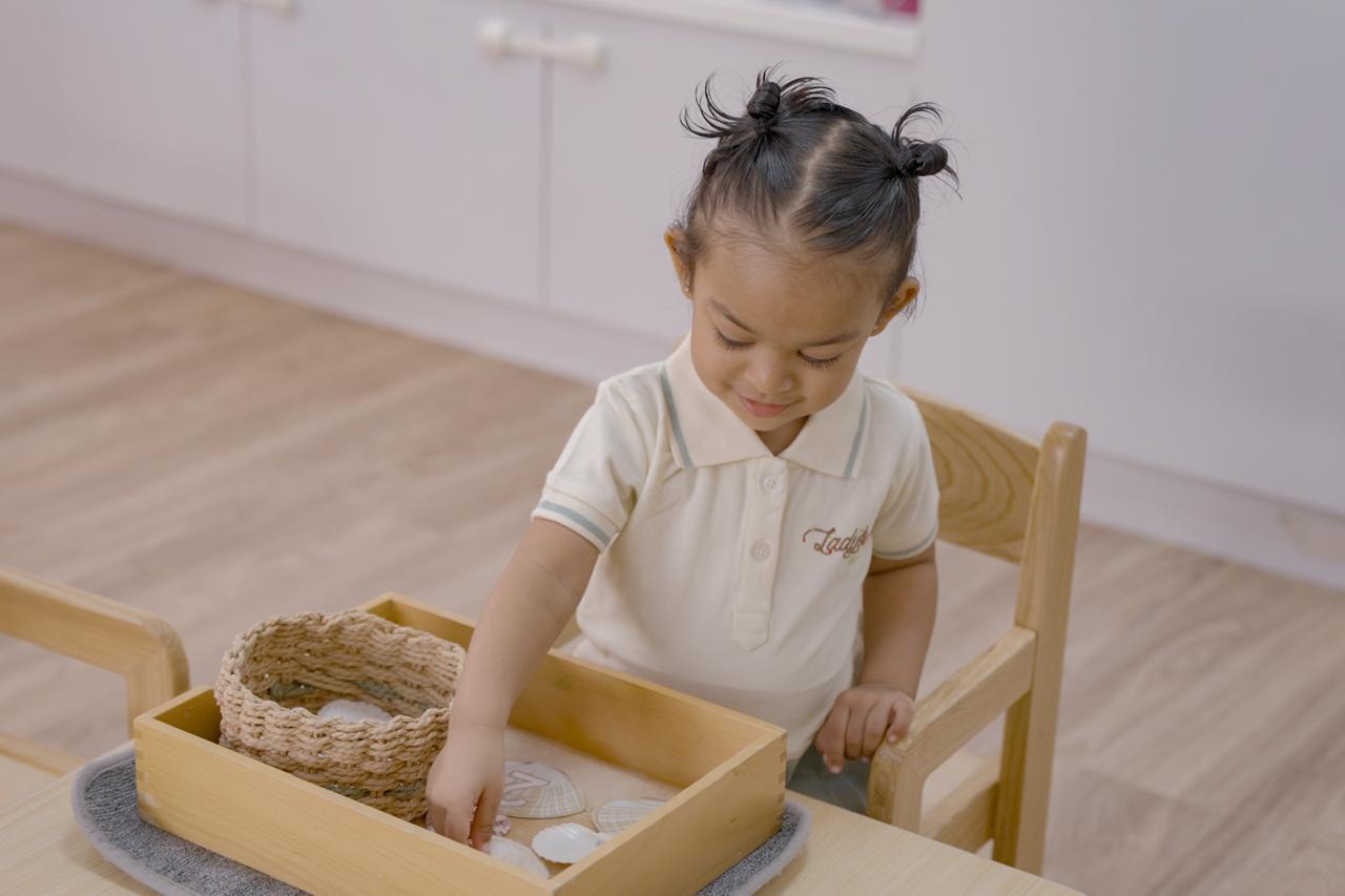 Toddler examining sea shells with a magnifying glass