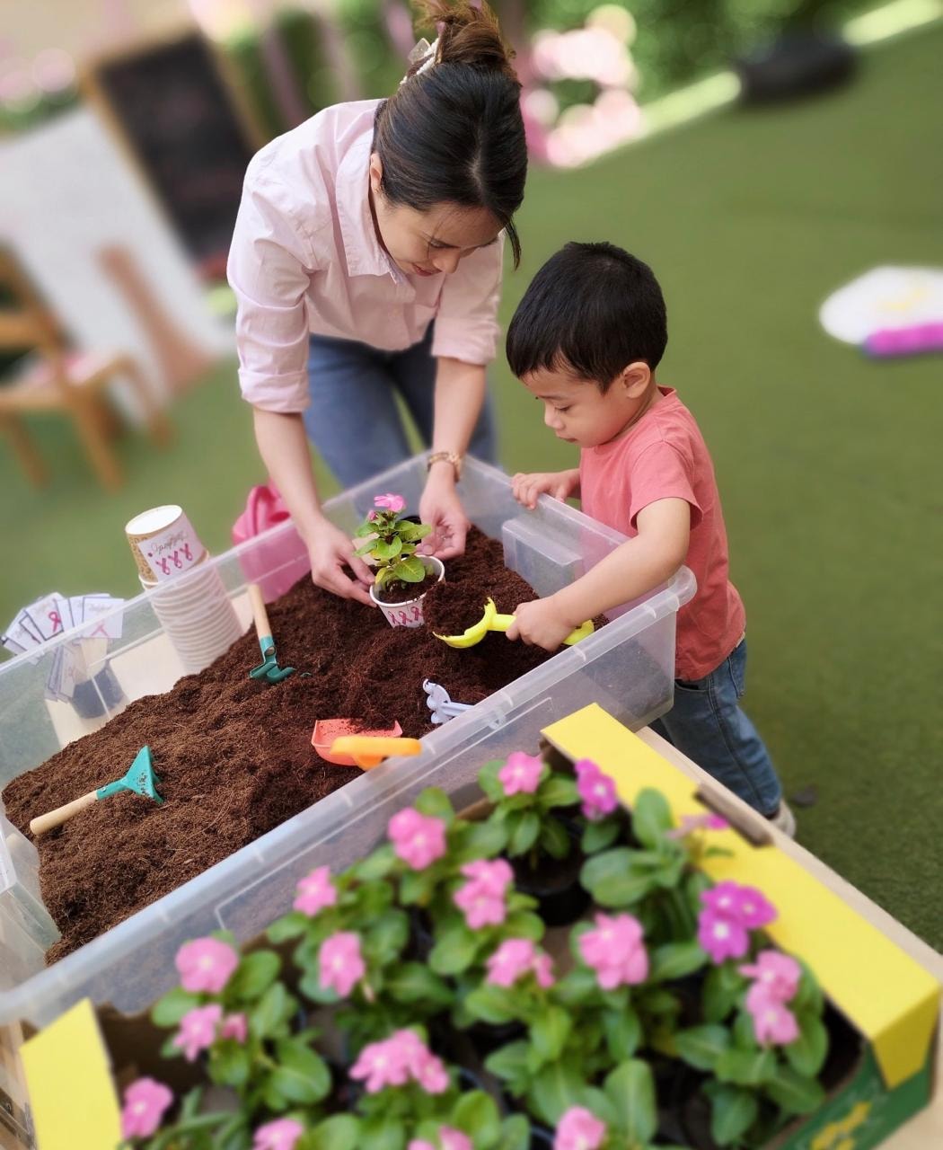 Mother and child gardening and potting flowers together at Ladybird Nursery