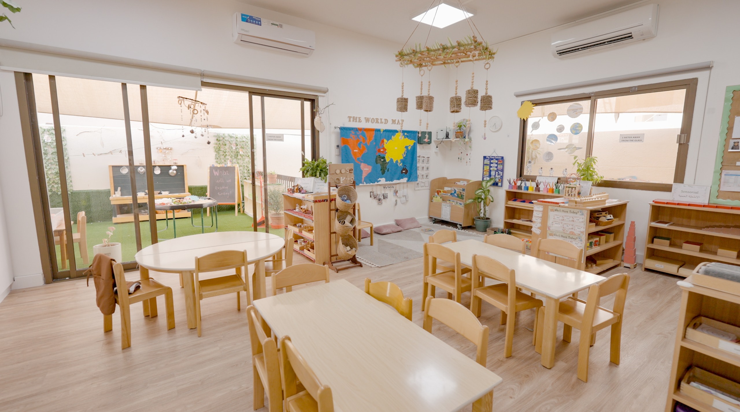 Bright Montessori classroom with world map and learning shelves
