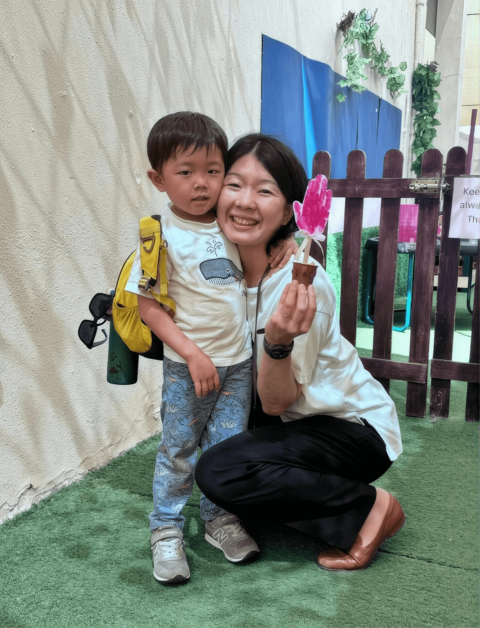 Parent and child sharing a warm moment with a handmade flower craft at Ladybird Nursery